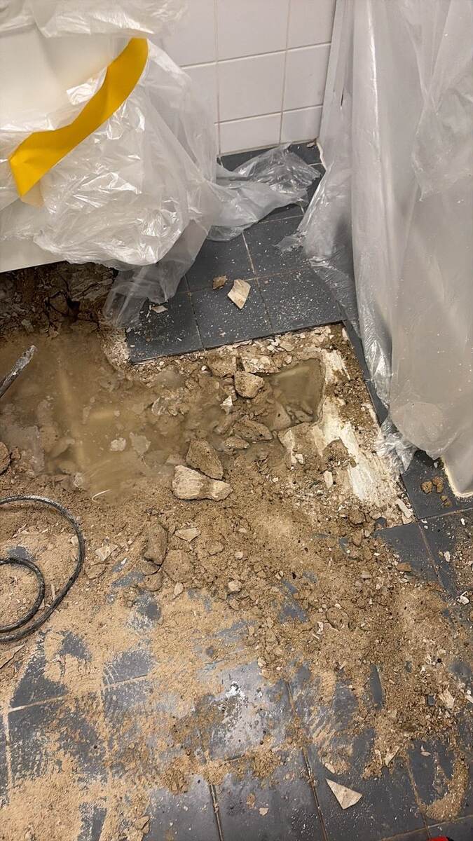 Opengebroken tegelvloer in een toiletruimte om bij de afvoerleiding te komen